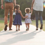 family walking down sidewalk