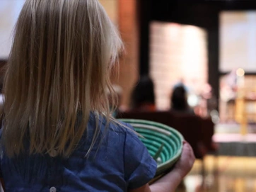 Girl with offering basket full